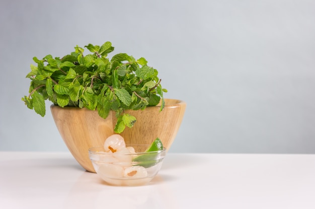 Bunch of fresh green basil in wooden bowl