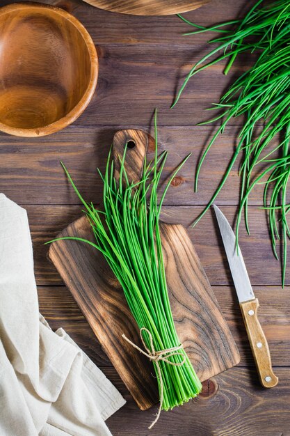 Photo a bunch of fresh green onions on a cutting board on the table spring vitamin harvest