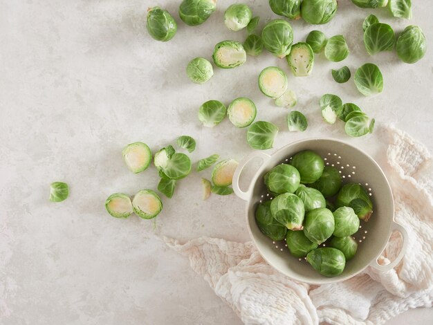 Photo a bunch of fresh green raw brussels sprouts on the countertop others in a colander top view