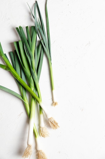 A bunch of fresh leeks on a white background