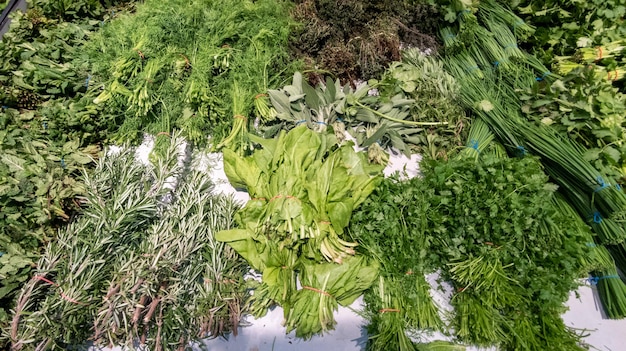 Bunch of fresh may herbs in market mint, basil, parsley and rosemary herb as background