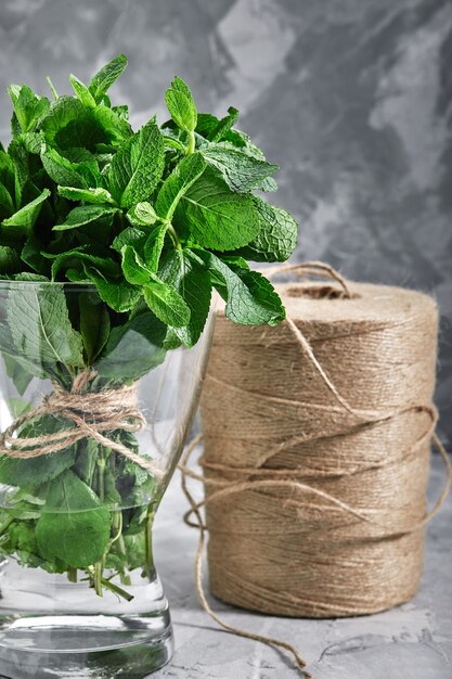 A bunch of fresh mint in a glass vase and water