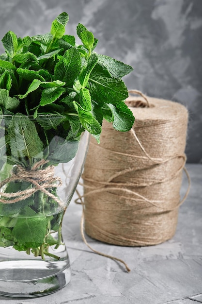 A bunch of fresh mint in a glass vase with water organic products for the store eco packaging food