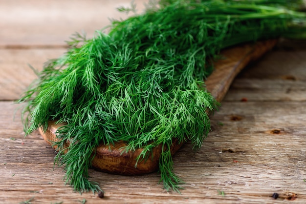 Bunch of fresh organic dill on wooden with copyspace, rustic and vintage style, selective focus