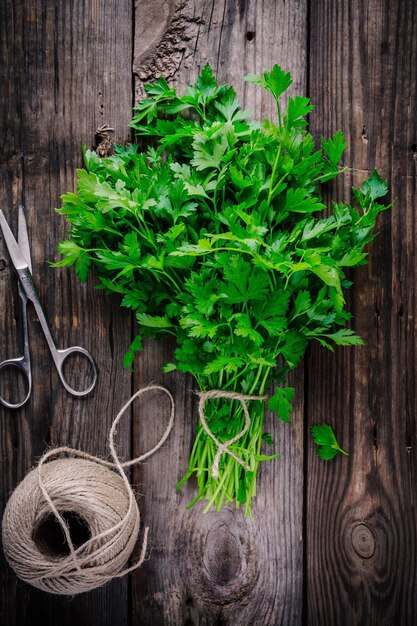 Bunch of fresh organic parsley on a wooden rustic background view from above