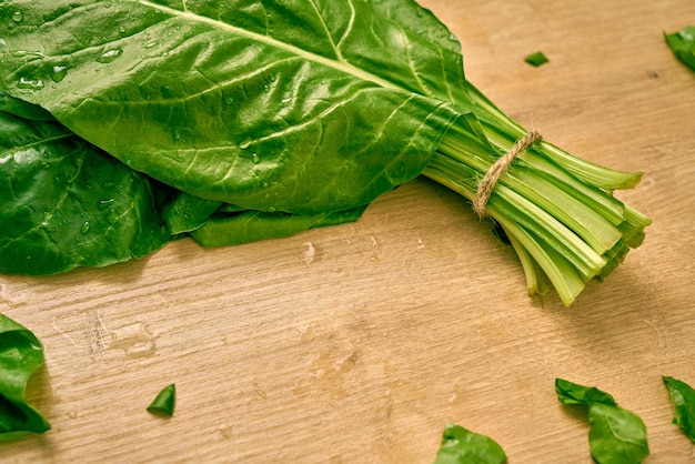 Bunch of fresh organic spinach on a wooden surface.