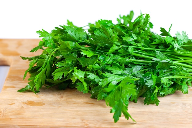 Bunch of fresh parsley and coriander vegetables on a wooden board white background