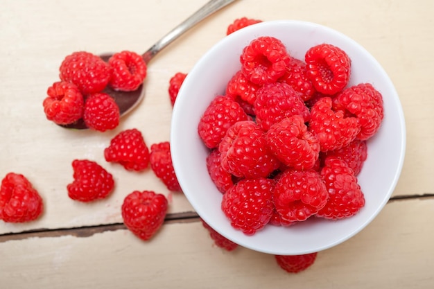 Bunch of fresh raspberry on a bowl and white table