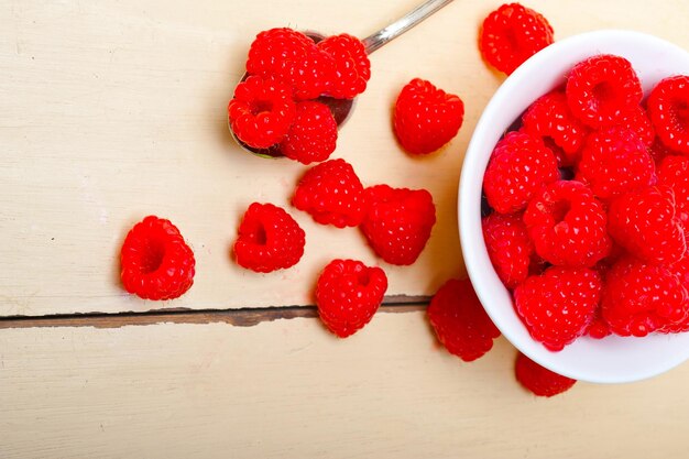 Bunch of fresh raspberry on a bowl and white table