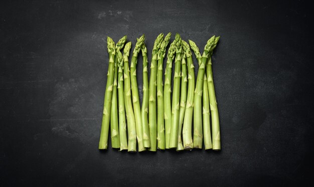 Bunch of fresh raw asparagus on a wooden black kitchen board a healthy product