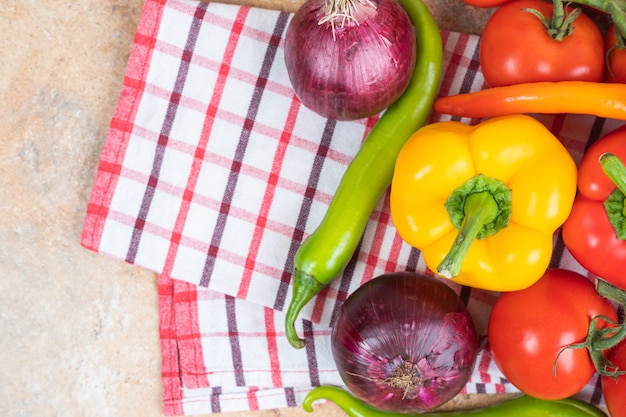 Bunch of fresh ripe vegetables placed on marble surface.