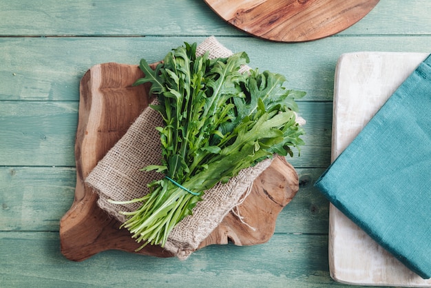 A bunch of fresh rocket leaves on a wooden table