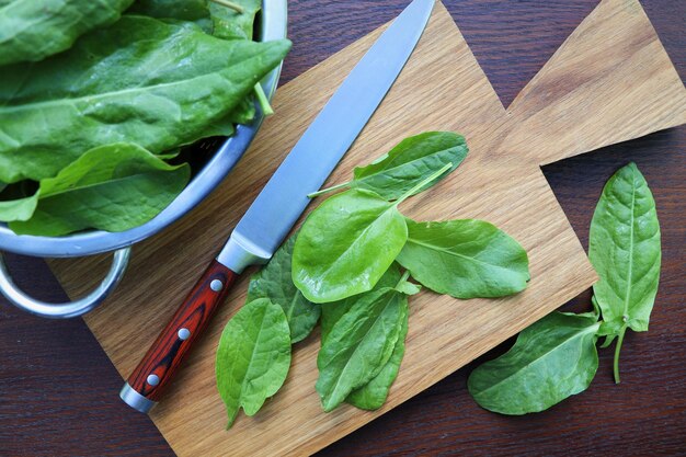 Bunch of fresh sorrel on wooden backgroundsorrel leaves on cutting board