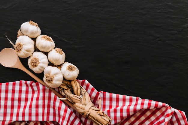 Bunch of garlic and spoon on napkin