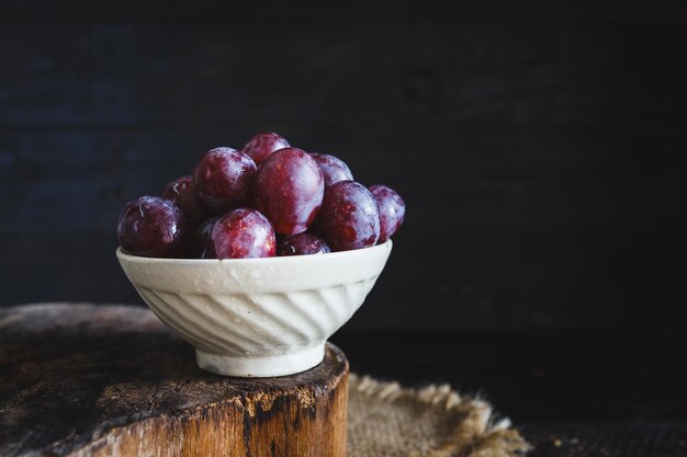 Bunch of grapes in bowl on wooden block