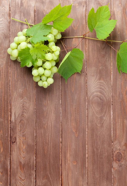 Bunch of grapes and vine on wooden table