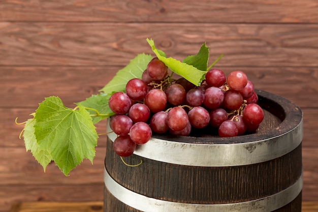 Photo bunch of grapes on wooden barrel
