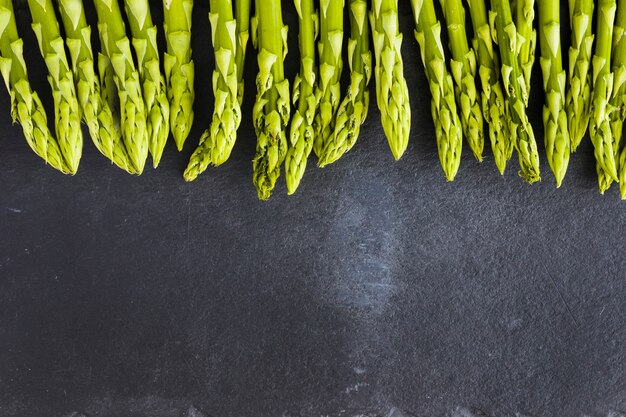 Bunch of green asparagus on a black pan