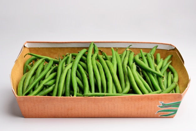 白い背景の上のボックスに緑色の豆の束