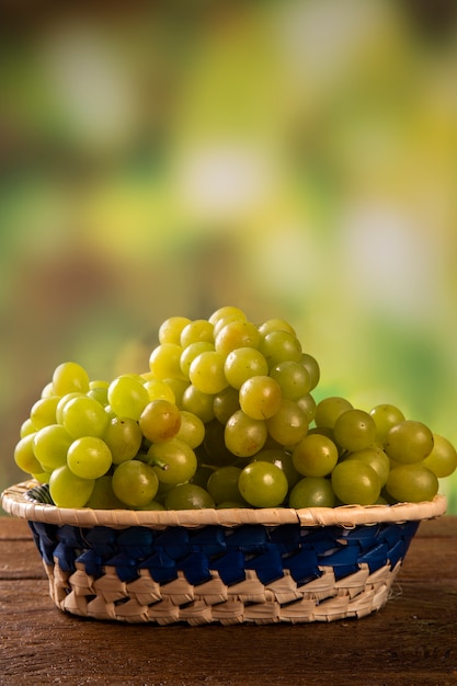 Bunch of green grapes, fruits of autumn, a symbol of abundance on rustic wood background.