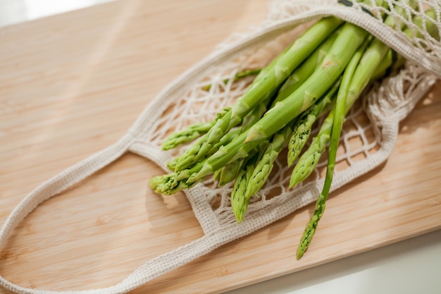 Bunch of green juicy asparagus in eco packaging on wooden board Healthy food Health Food