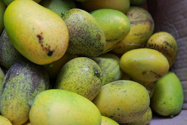 Photo a bunch of mangoes in a basket