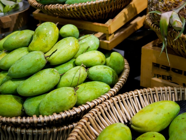 A bunch of mangos on basket.