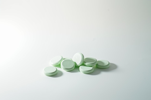 Photo a bunch of medicinal pills and antibiotics, white medical tablets, light green, with copy space