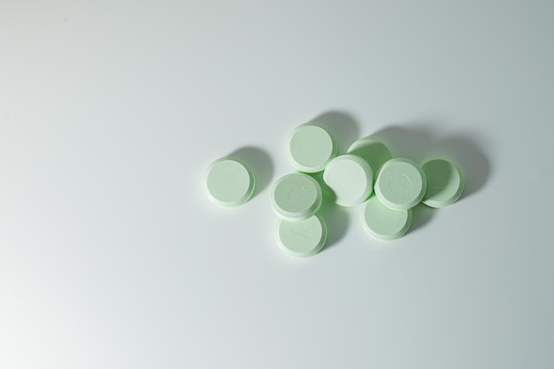 A bunch of medicinal pills and antibiotics, White medical tablets, light green, with copy space