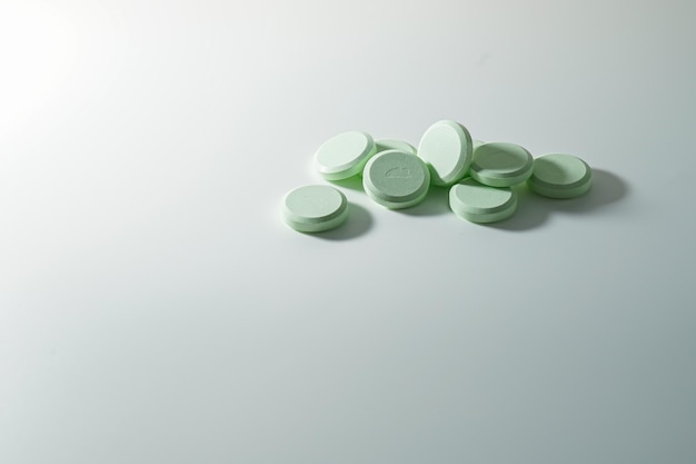 A bunch of medicinal pills and antibiotics, White medical tablets, light green, with copy space