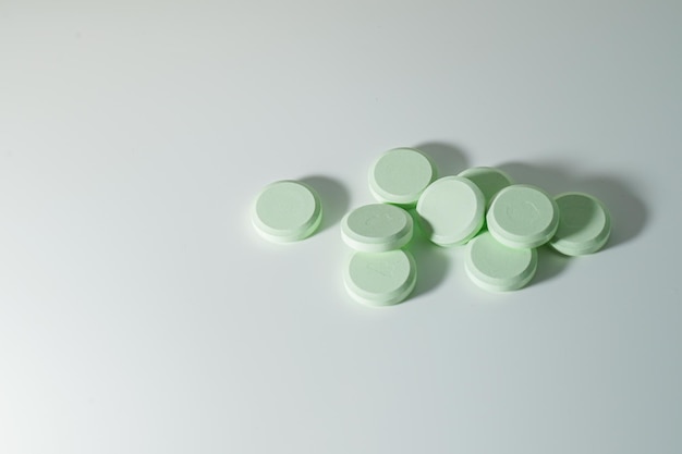 A bunch of medicinal pills and antibiotics, White medical tablets, light green, with copy space