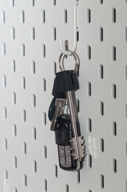 A bunch of modern keys hangs on a clothes hook in the hallway
closeup