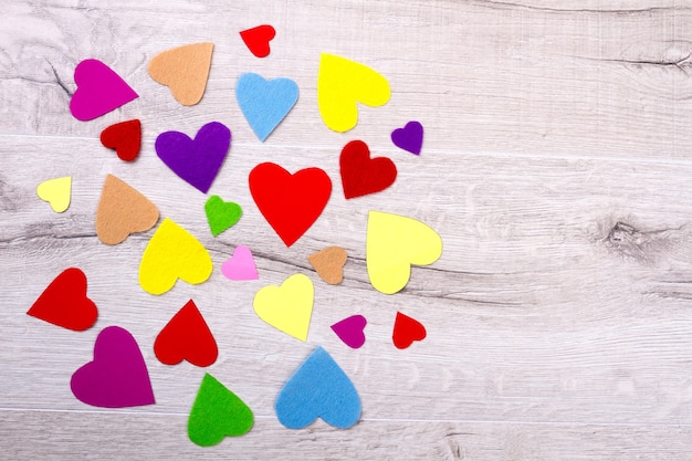 Bunch of multicolored hearts. Colorful hearts on wooden surface. Romantic surprise on a table. Magic of colours.