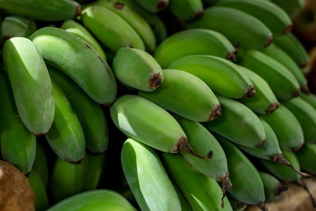 Букет из больших бананов на витрине с фруктами на рынке. фото высокого качества