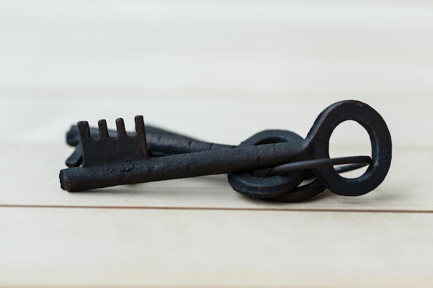 Bunch of old decorative black keys on a wooden background