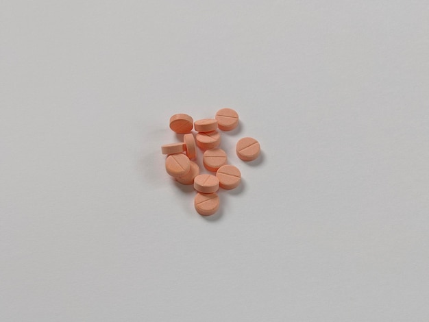 A bunch of orange pills are on a white background
