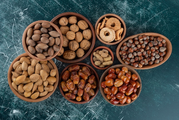 Bunch of organic fresh nuts placed on marble table.