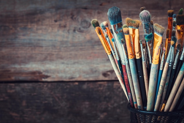 Bunch of paint brushes in a artist studio Copy space for text Retro toned photo