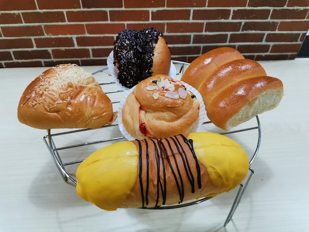 A bunch of pastries on a wire rack with one that has a banana on it.