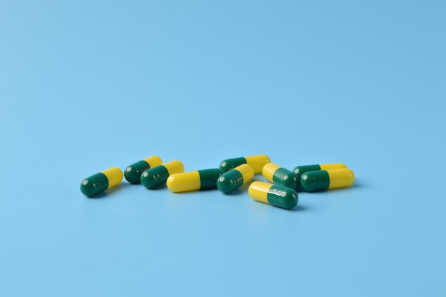 Bunch of pill capsules isolated on a blue background Health concept