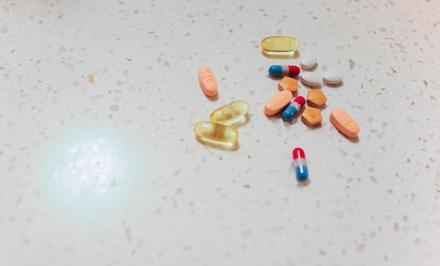 A bunch of pills are on a table with one of them being labeled " capsules ".