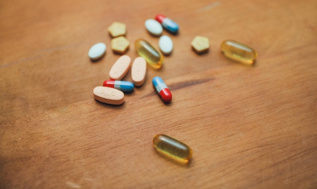 A bunch of pills on a wooden table