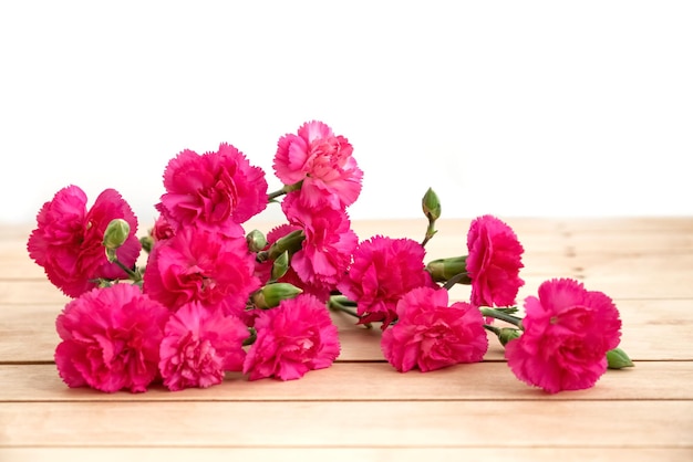 나무 테이블 표면에 분홍색 카네이션 꽃 다발