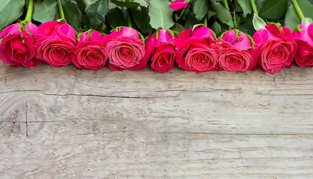 A bunch of pink roses on a wooden table