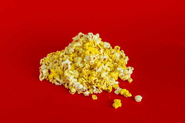 Un mucchio di popcorn è caduto sulla superficie piatta del colore