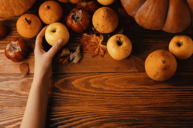 カボチャとリンゴの束暗い木製の素朴なテーブルの上のカボチャの山秋の構成...