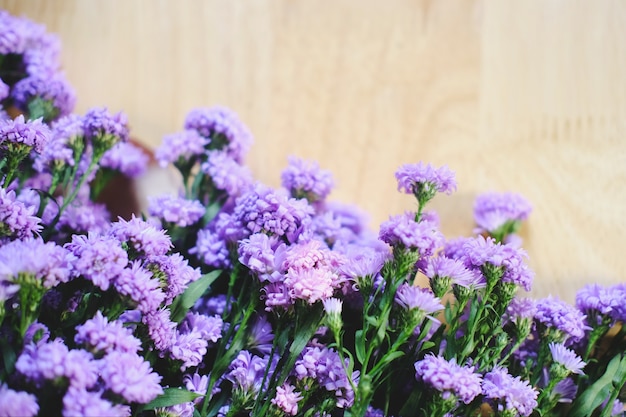 Il mazzo di margherita porpora marguerite fiorisce su fondo di legno viola viola per il concep 2018