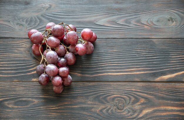 Bunch of red grape on the wooden background