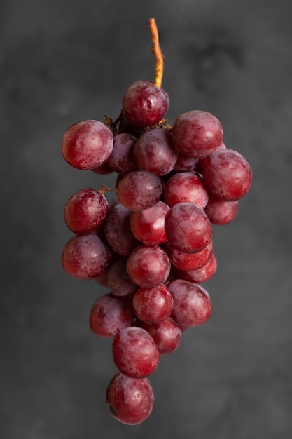 Bunch of red grapes besides concrete