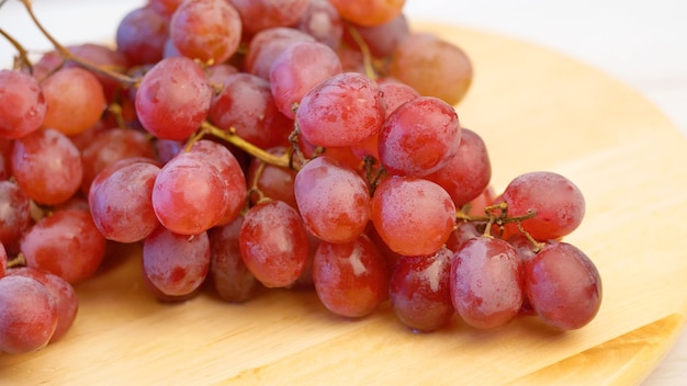 Bunch of red grapes on wooden board